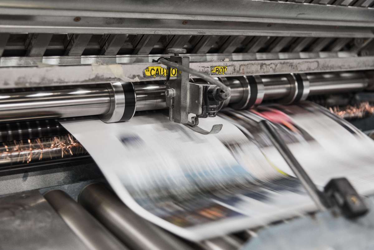 zoomed in image of industrial printer printing newspaper articles