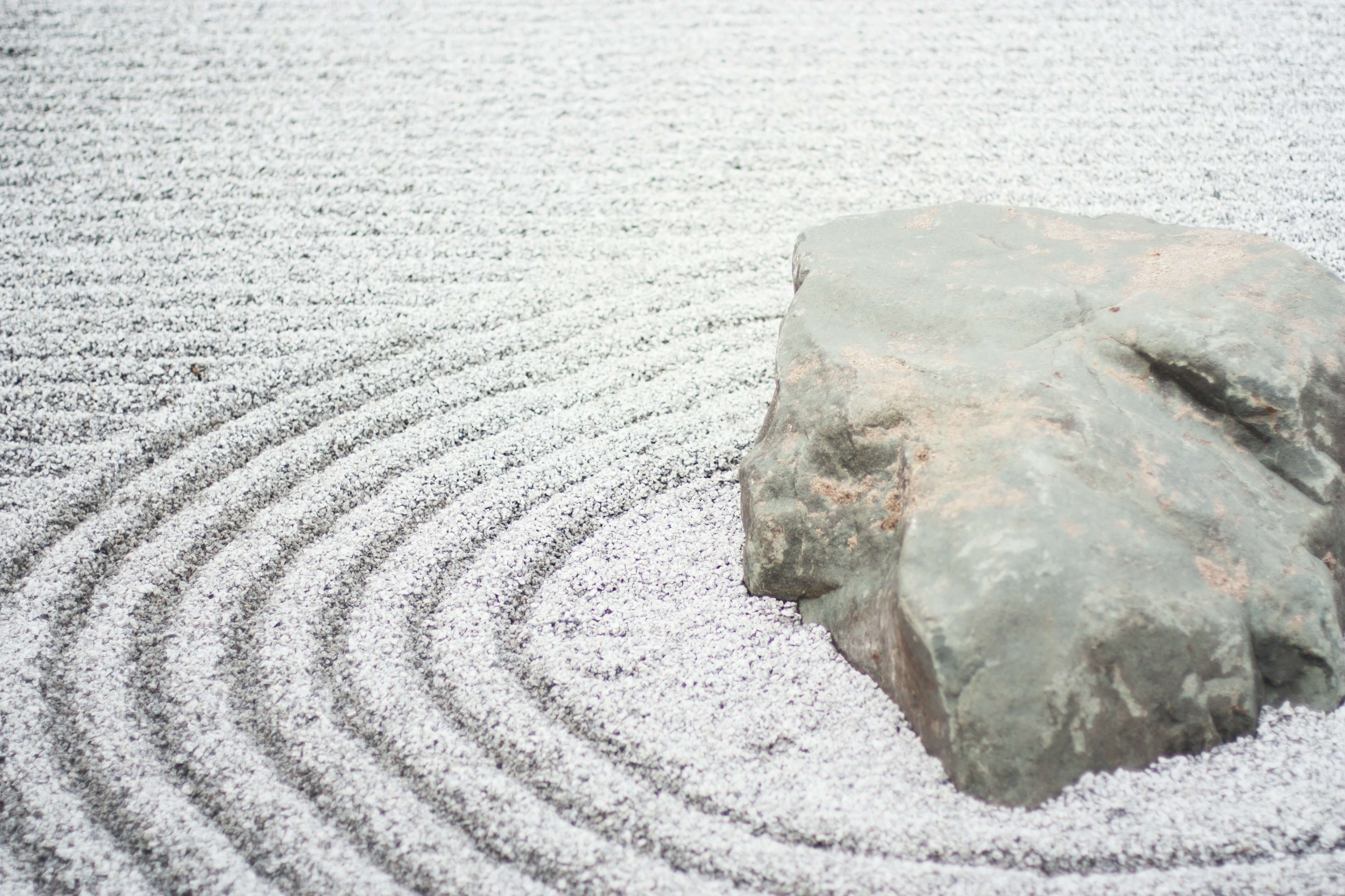 close up of zen garden and giant rock